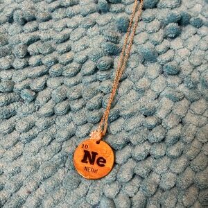 Neon element pendant on a gold chain